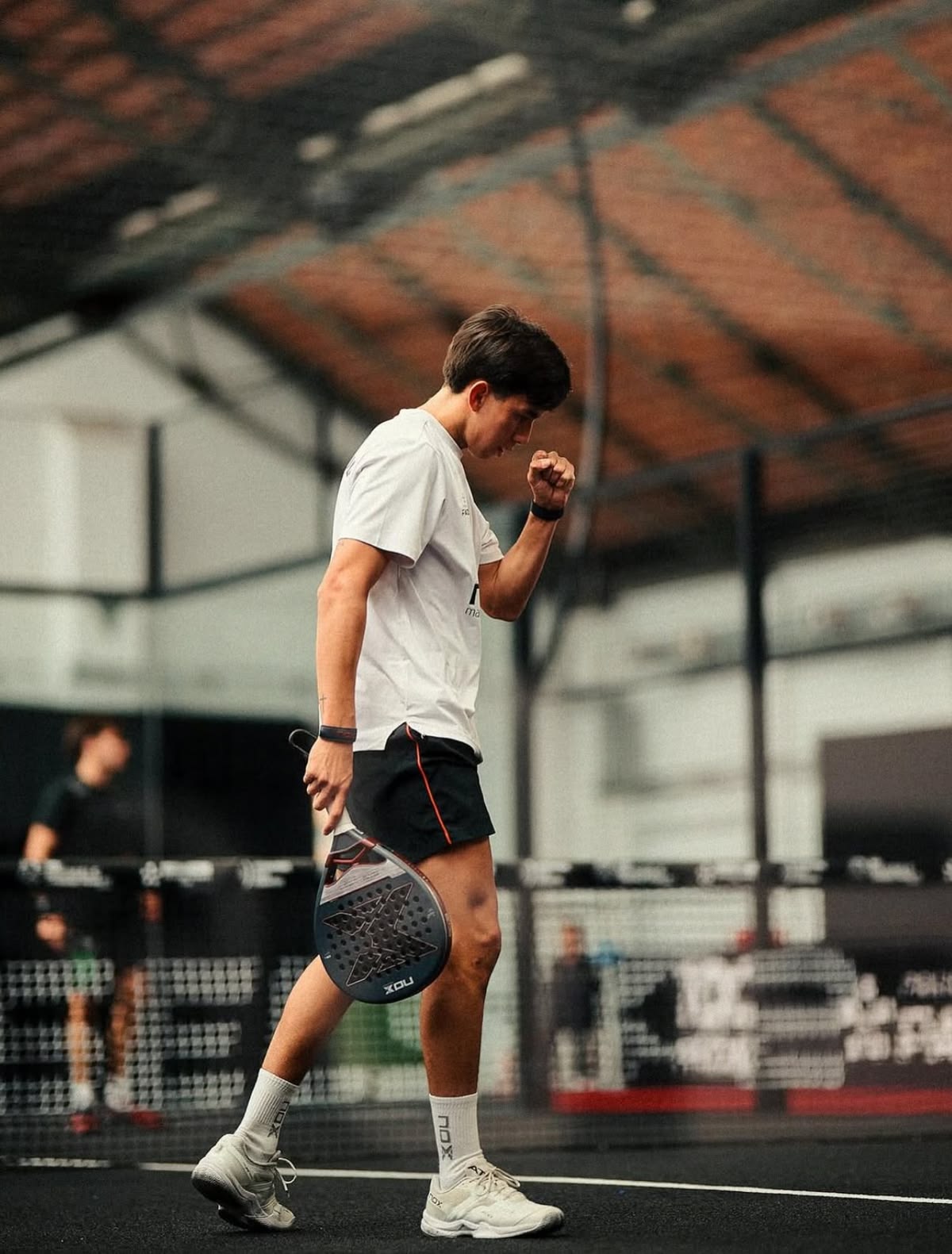 Male padel player celebrating on court